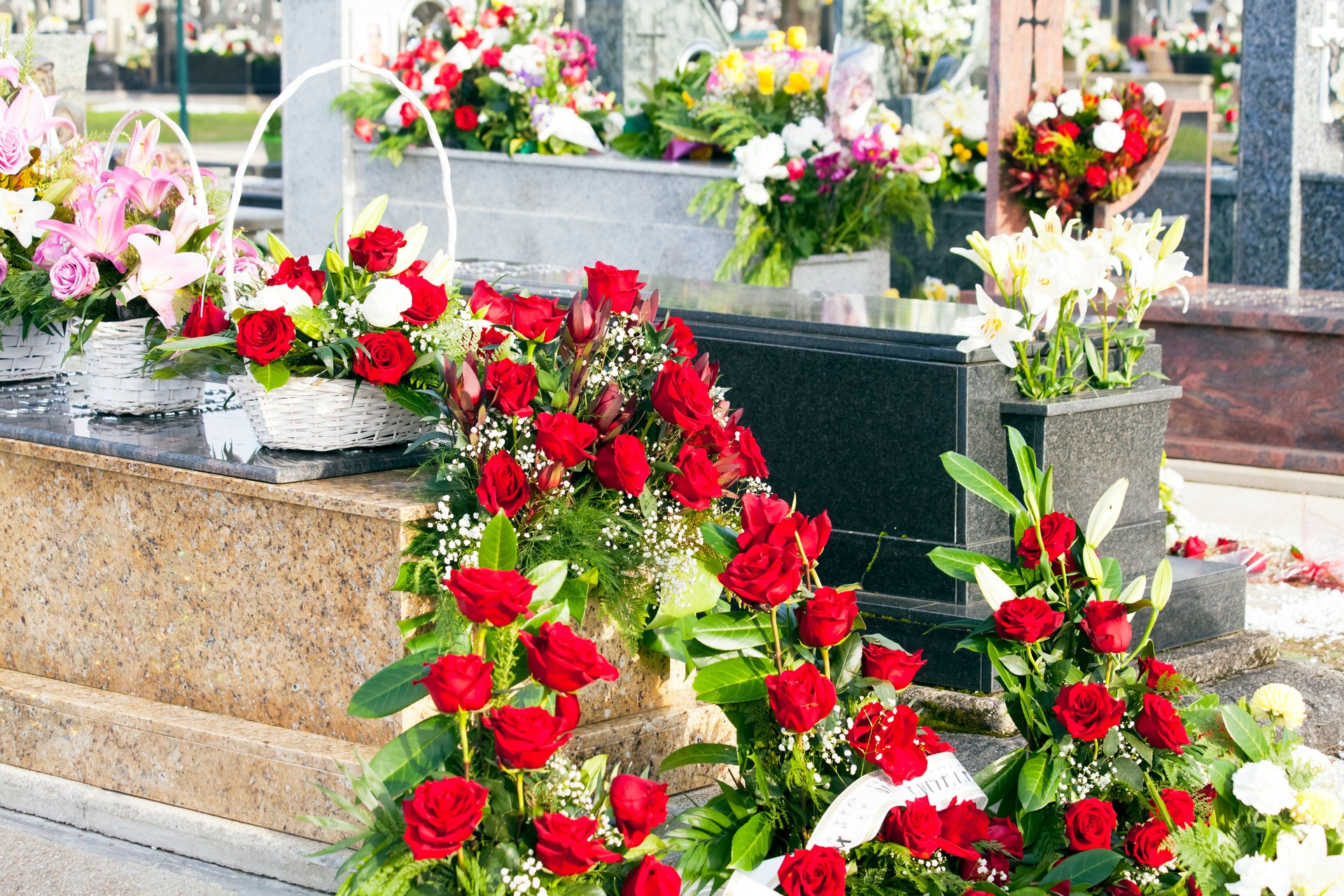 Stone tombstones and flowers in a graveyard.